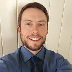 A person wearing glasses and smiling at the camera

Description automatically generated