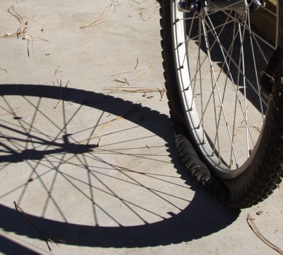 Flat bicycle tire on concrete with shadow