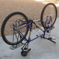 Mountain bike flipped over, resting on saddle, handlebars