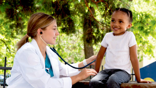 Photo of a female nursing student with a stethoscope on the back of a child