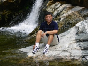 Xiaomin relaxing near a waterfall in China, 2007